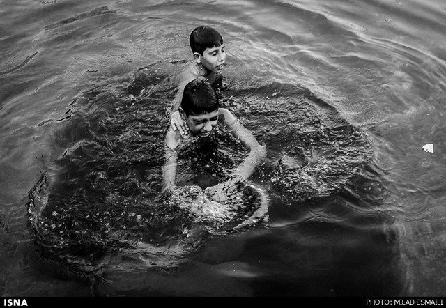 آبتنی کودکان در حوضچه‌های شهری اهواز (عکس)