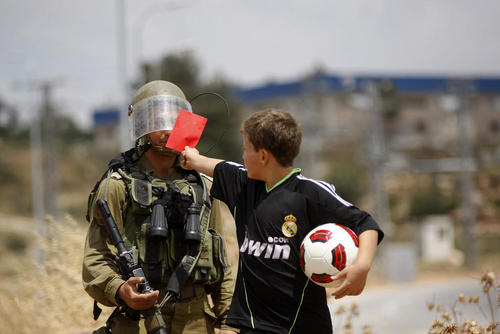 کارت قرمز نوجوان فوتبالیست فلسطینی به سرباز اسراییلی در اعتراضات علیه فدراسیون فوتبال اسراییل در رام الله