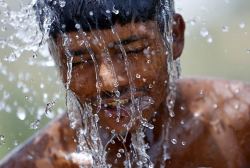 کارگر هندی در گرمای طاقت فرسا در حال گرفتن دوش زیر آب یک تانکر . گرمای بی سابقه در هند در هفته های گذشته جان نزدیک به 2 هزار نفر را گرفته است
