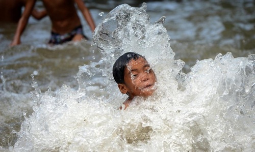 کودکان فیلیپینی در شدت گرمای هوا داخل کانال آب رفته اند