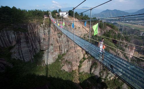 عبور از یک پل معلق کف شیشه ای در استان هونان چین