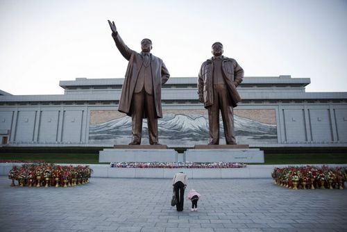 تعظیم یک مادر و دختر به مجسمه های دو رهبر سابق کره شمالی در پیونگ یانگ