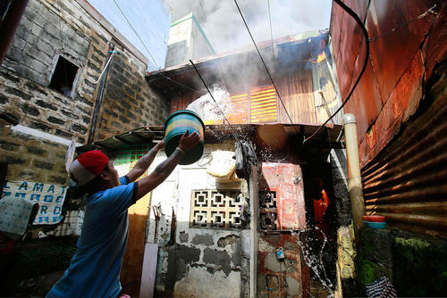 خاموش کردن آتش سوزی خانه در یک منطقه حومه ای در شهر پاراناگ فیلیپین
