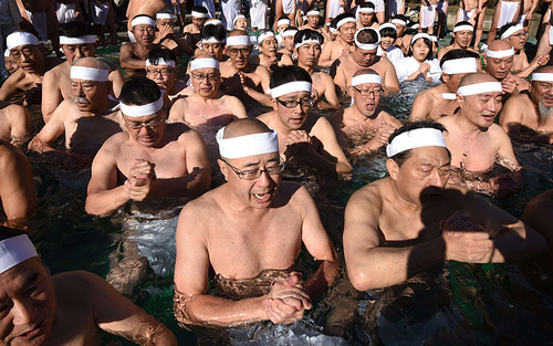 نیایش هواداران آیین شینتو درون استخر آب یخ در جشن سال نو – توکیو