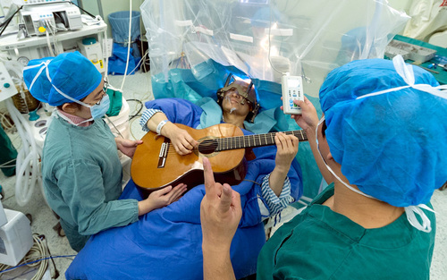 مرد 57 ساله چینی در شهر شنزن زیر عمل جراحی مغز در حال نواختن گیتار است. این هفتمین عمل جراحی به روش 