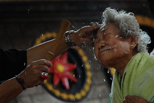 پاشیدن آب روی صورت زائران معبدی در سورابایای اندونزی