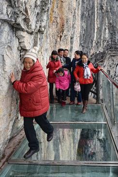 عبور توریست ها از پل شیشه ای 1 کیلومتری در ارتفاع 100 متری در یک پارک ملی در استان گویژو