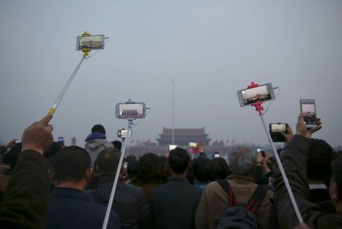 گرفتن عکس از مراسم برافراشته شدن پرچم چین در میدان تیان آن من پکن همزمان با برگزاری نشست کنگره ملی خلق این کشور