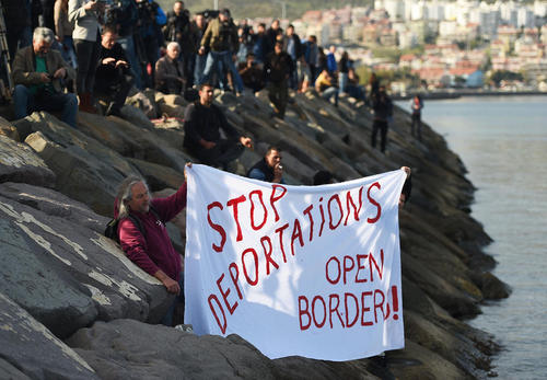 مخالفان ورود پناهجویان در ساحل شهر بیکیلی ترکیه با پارچه نوشته هایی در دست در مخالفت با ورود پناهجویان به این شهر به استقبال آنها آمدند