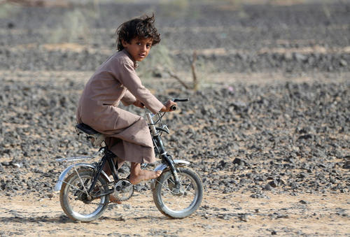 دوچرخه سواری کودک پاربرهنه یمنی در شهر مارب
