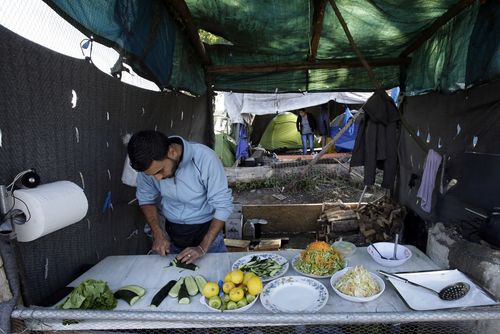 مرد پناهجوی سوری در حال آشپزی در آشپزخانه صحرایی در مرز یونان و مقدونیه