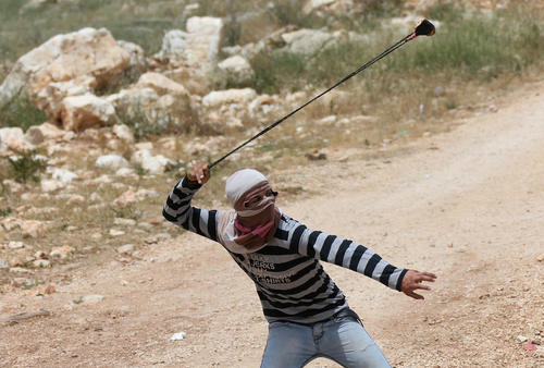 جوان فلسطینی در حال پرتاب سنگ به سمت سربازان اسراییل – نابلس
