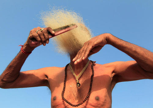 شانه زدن ریش پس از آب تنی مرد هندو در رود – هند