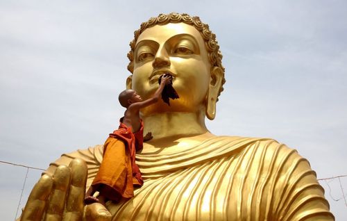 یک راهب کودک هندی در حال تمیز کردن یک مجسمه در معبدی در بوپال هند