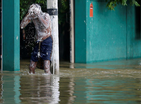 استحمام یک مرد در سیلاب شهر بیاگاما در سریلانکا