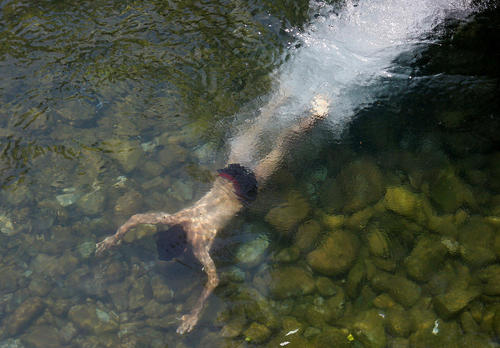 آب تنی نوجوان کشمیری در رودخانه برای در امان ماندن از گرمای هوا