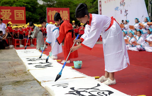 دانش آموزان چینی با لباس سنتی در حال خوش نویسی چینی – گینگژو