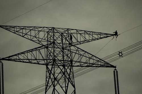 کارگران در حال کار روی دکل های بزرگ انتقال برق – هند