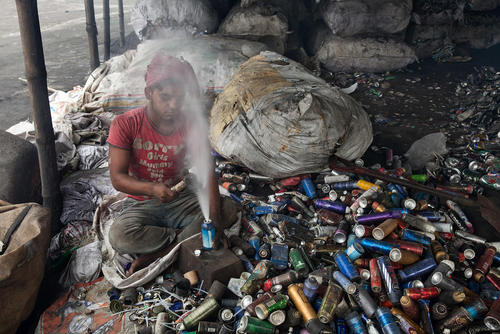 جوان بنگلادشی در حال سوا کردن قطعات آلومینیومی از زباله های صنعتی