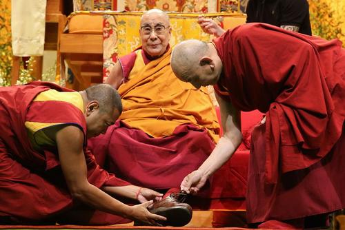 جلسه درس دالایی لاما رهبر در تبعید بوداییان تبت برای راهبان بودایی در شهر استراسبورگ فرانسه . راهبان در حال درآوردن کفش دالایی لاما هستند