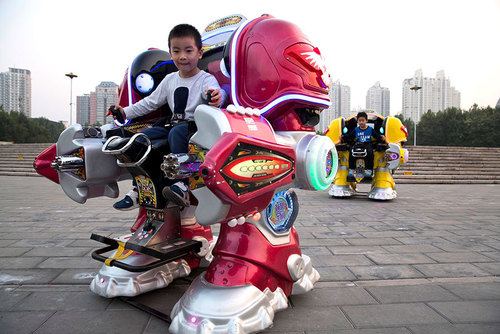 سوار شدن کودکان روی ماشین روبات بزرگ در پارکی در شهر پکن