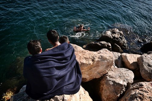 آب تنی پناهجویان در سواحل صخره ای در جزیره چیوس یونان