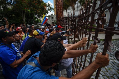 هواداران نیکولاس مادورو رییس جمهور ونزوئلا دروازه ورودی ساختمان پارلمان را می شکنند تا اعتراض خود را به جلسه اضطراری پارلمان این کشور با درخواست اپوزیسیون این کشوردرباره آینده مادورو ابراز کنند