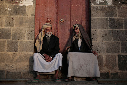 دو یمنی در مقابل خانه ای در صنعا نشسته اند