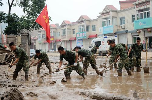 سربازان چینی در حال تمیز کردن خیابان از گل و لای و استحکام بندی در برابر سیل 