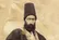 تصویری از «خطاط مشهور دوران قاجار» در کنار یکی از نوشته‌هایش